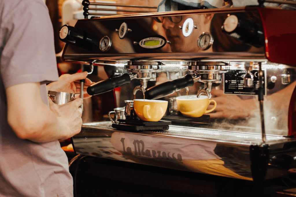 Homem fazendo café numa máquina profissional. Fonte: Pexels